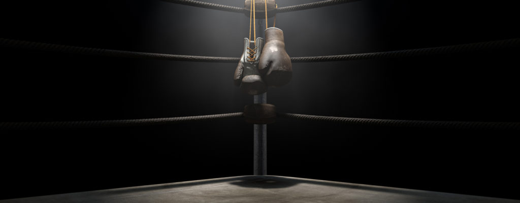 Boxing gloves hanging in the corner of a ring