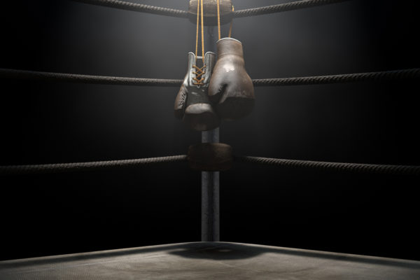 Boxing gloves hanging in the corner of a ring